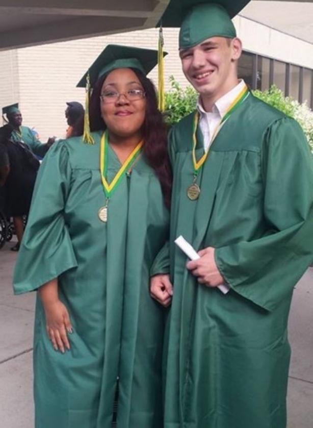 two high school graduates posing for photo